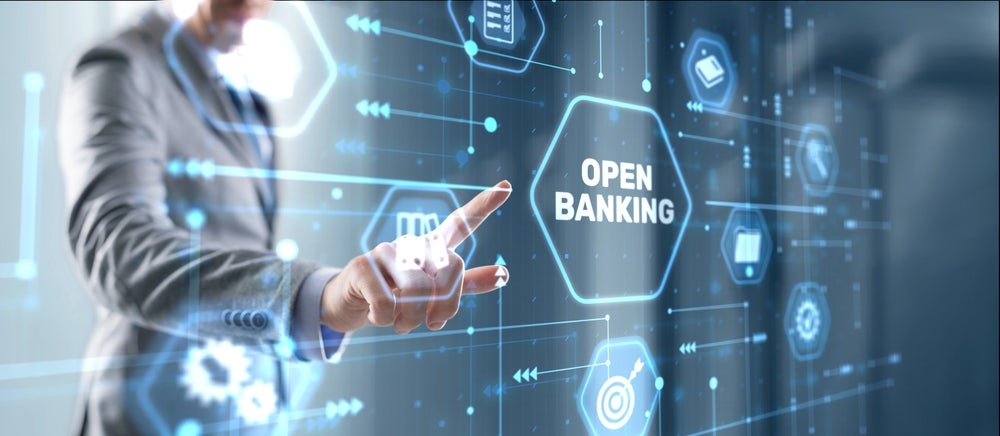 Hand interacting with a digital interface displaying 'Open Banking'.